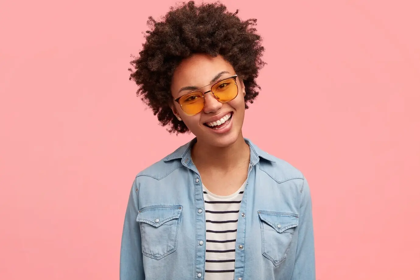 Красивая женщина с аккуратно уложенными волосами и широкой улыбкой, обнажающей зубы; она отлично себя чувствует после выходного дня и рада получить хорошую обратную связь.