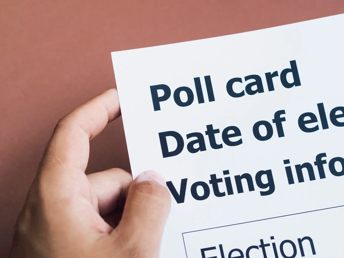 Вид сверху на мужчину, держащего избирательную карточку.